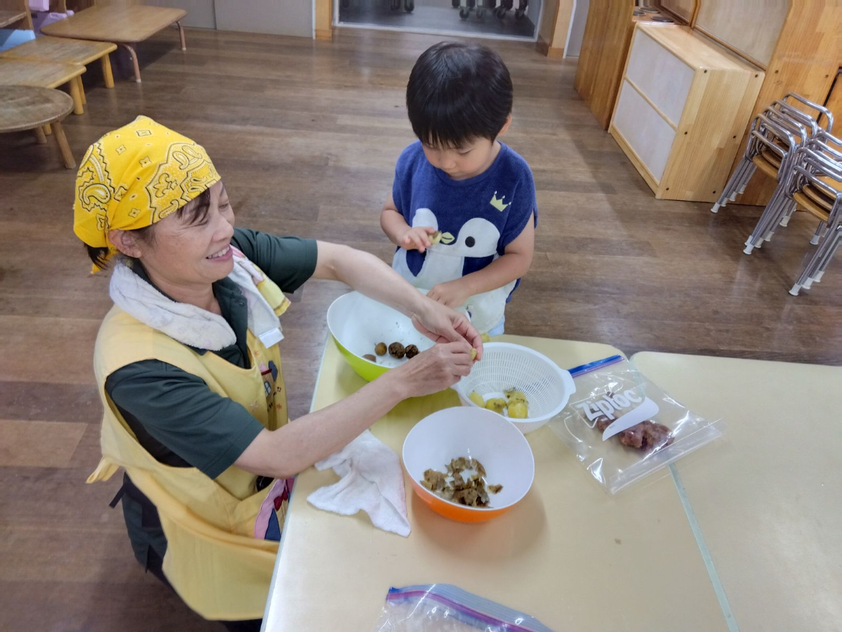 温めたじゃがいもを潰す子ども