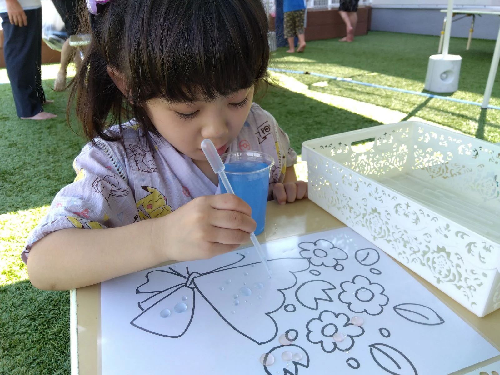 色水で塗り絵をする子ども