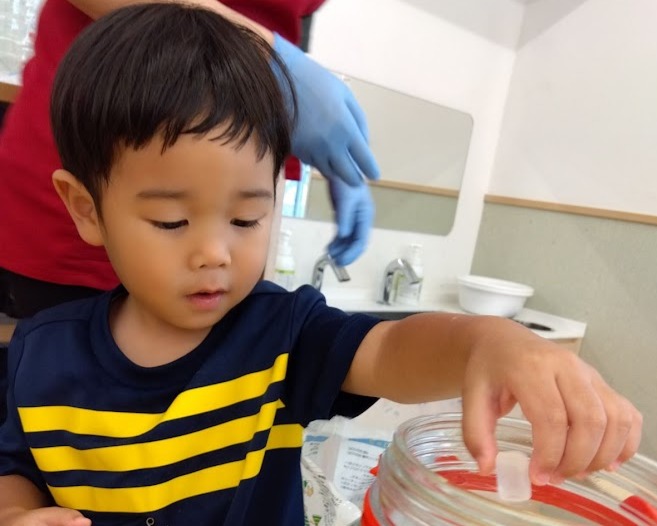 容器に氷砂糖を入れる子ども