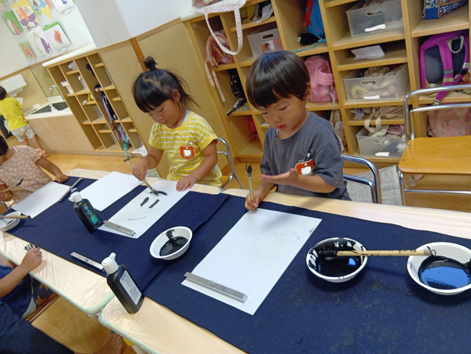 墨で文字を書く子どもたち