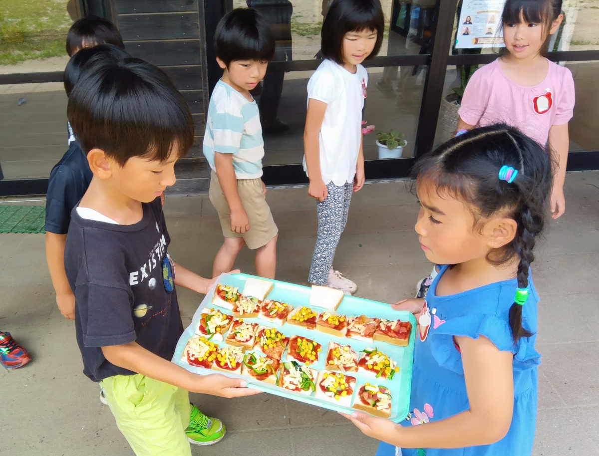 ピザを運ぶ子どもたち