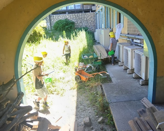 園庭での虫捕りをする子どもたち