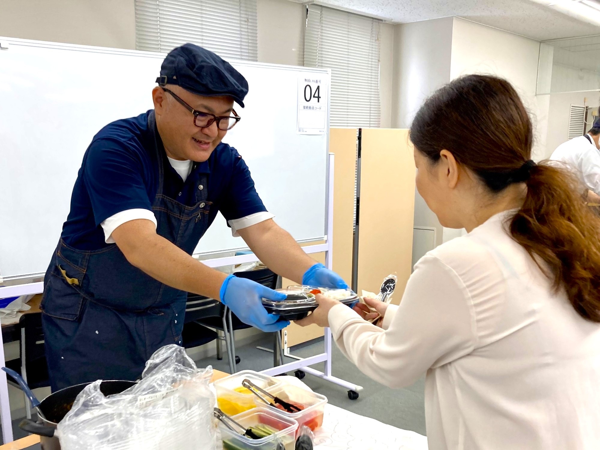 職員がお客様にスパイスカリーを手渡す様子