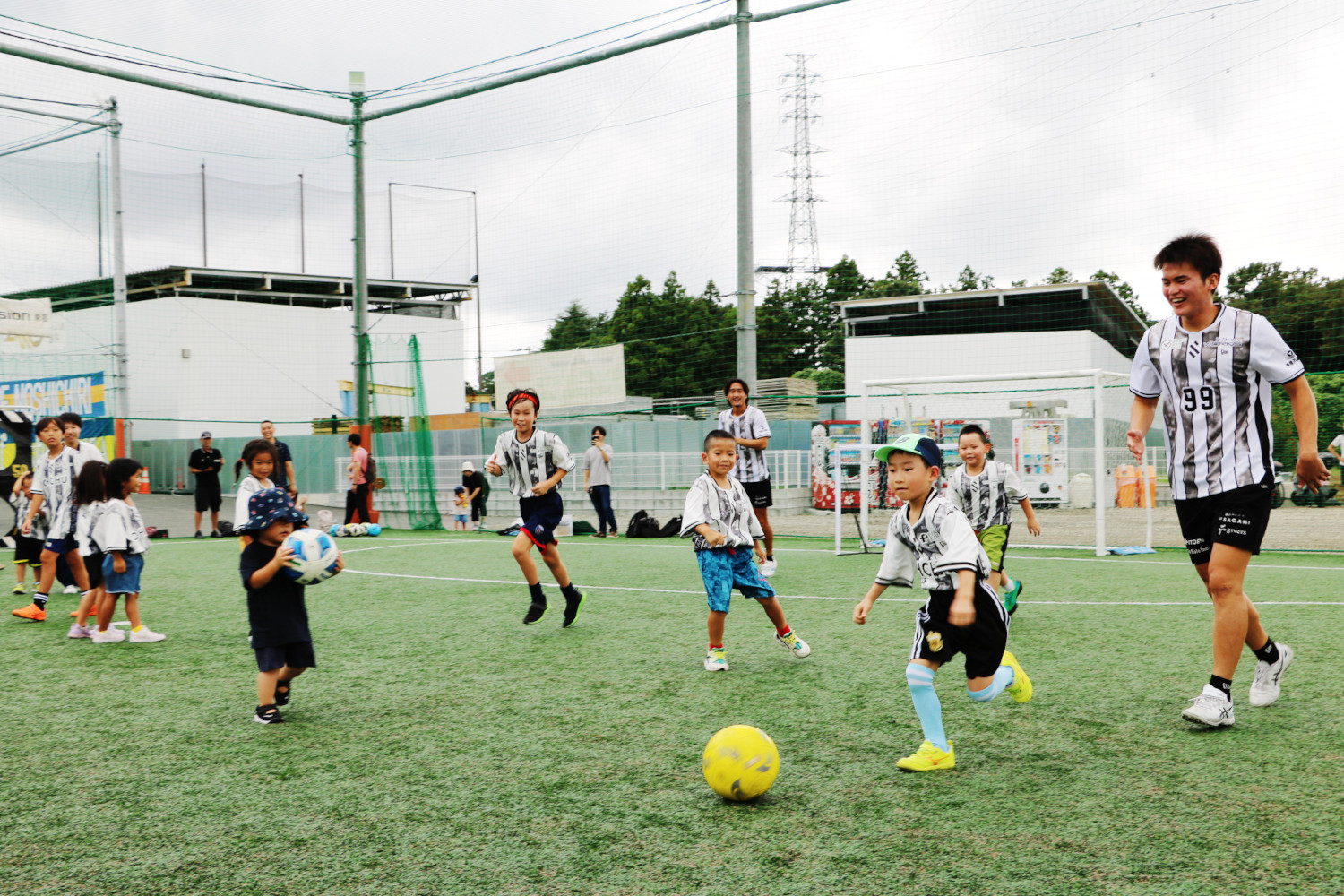 選手とサッカーをして遊ぶ子どもたち