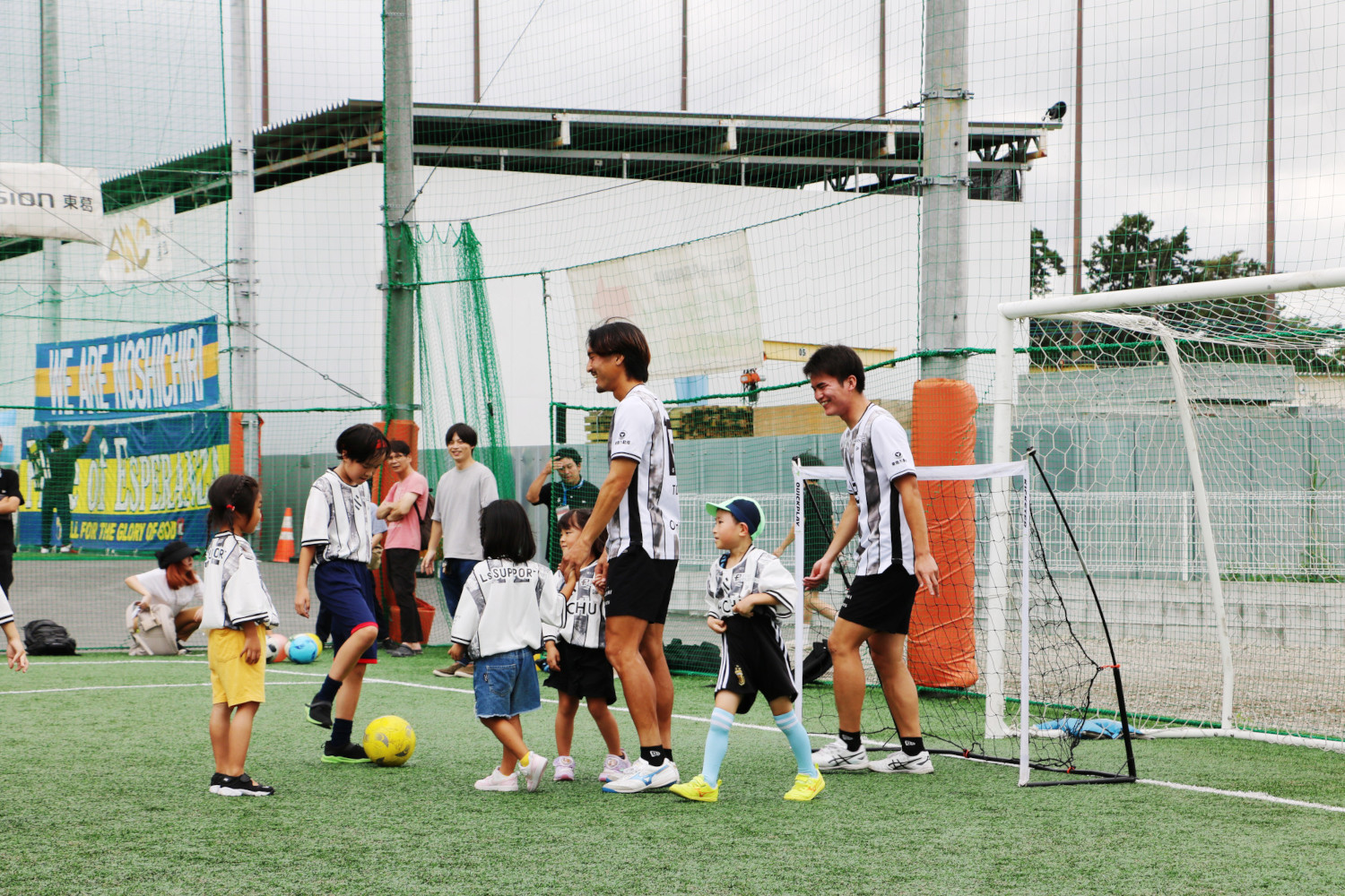 選手とサッカーをして遊ぶ子どもたち
