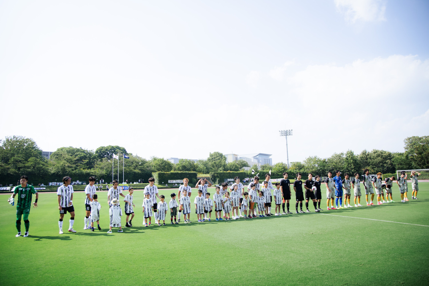 ピッチに立つ選手と子どもたち