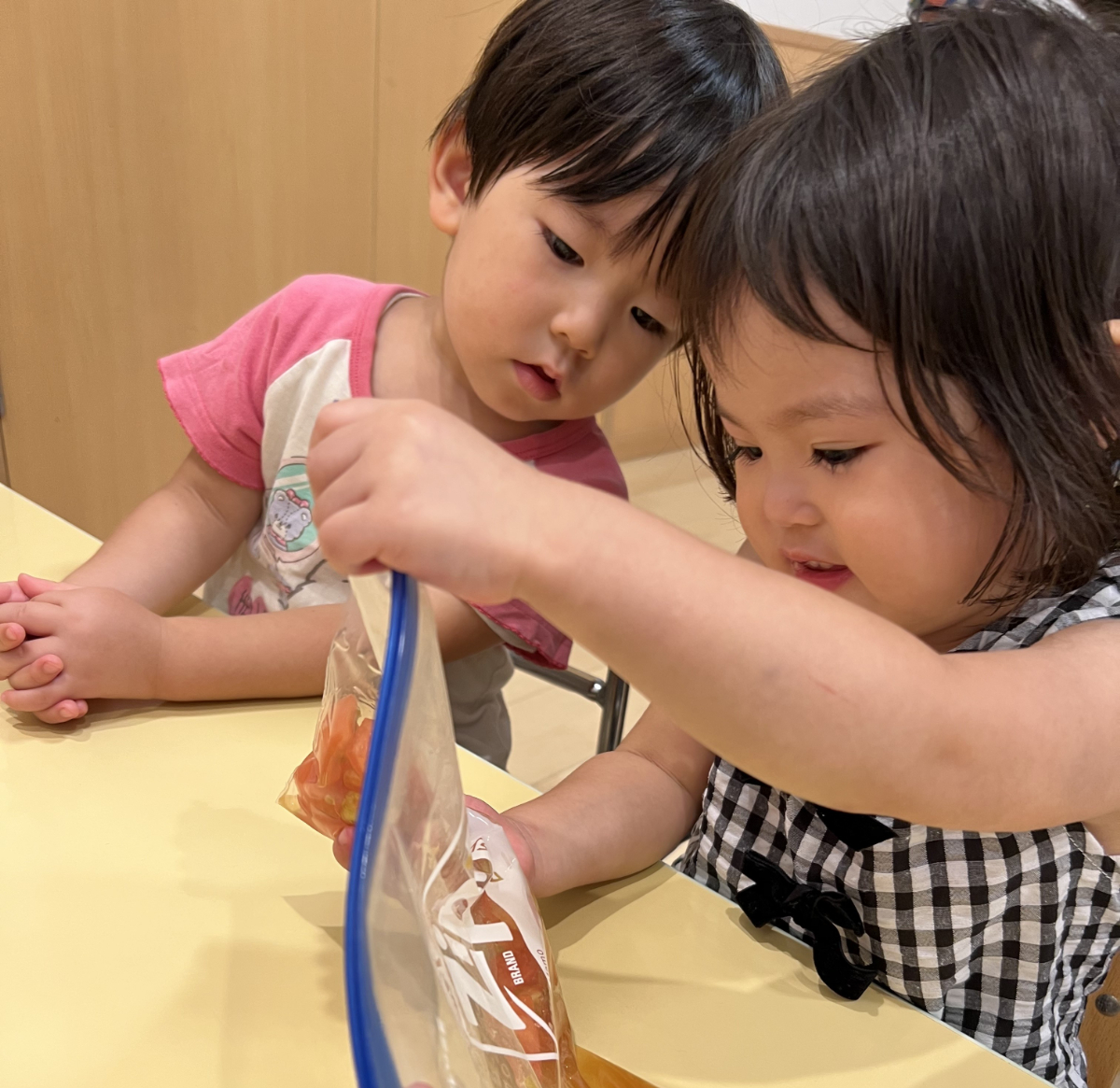 ポリ袋に入れたトマトを潰す子どもたち