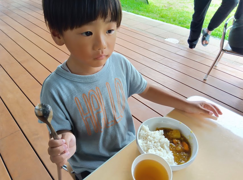 作ったカレーを食べる子ども