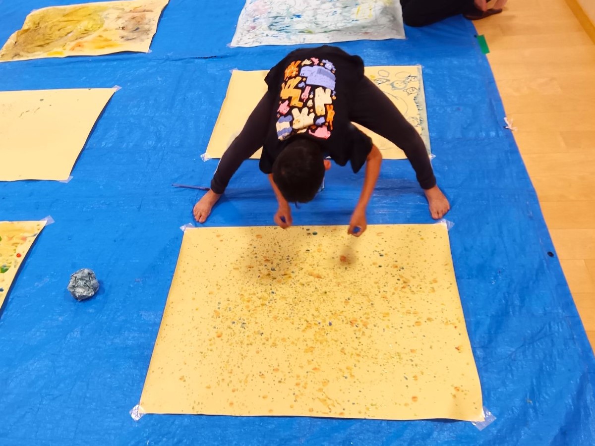 色のついた氷で絵を描く子ども