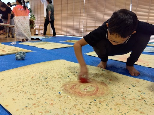 色のついた氷で絵を描く子ども