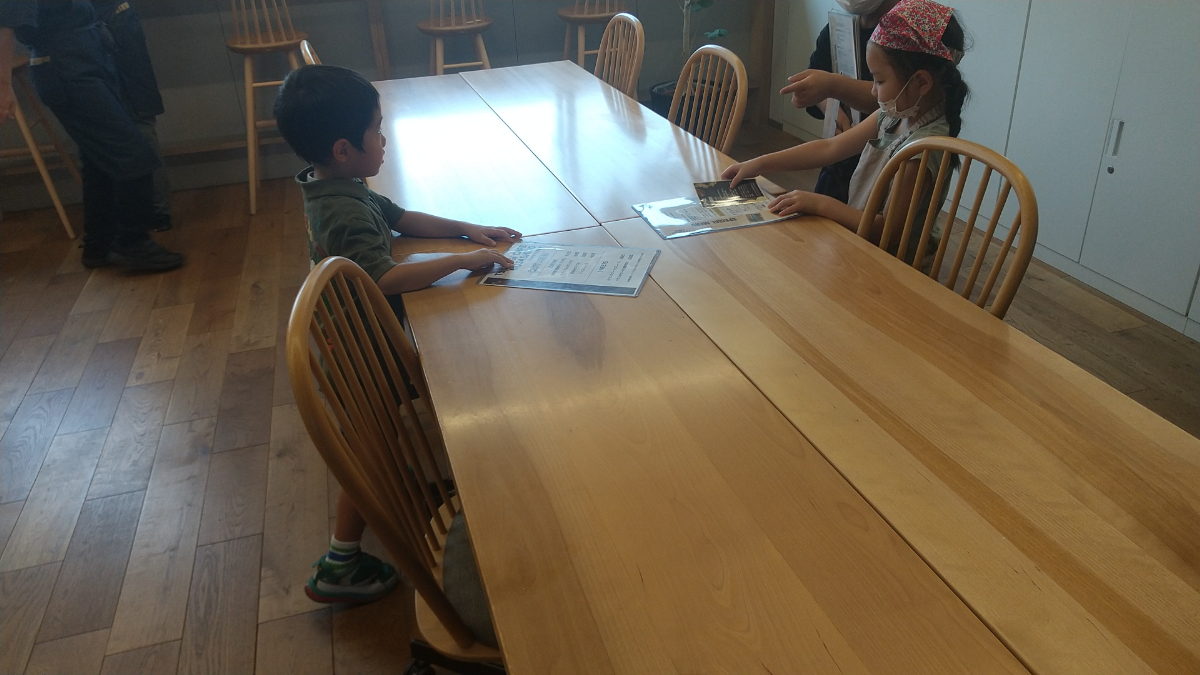 カフェのメニュー表をテーブルに置く子どもたち