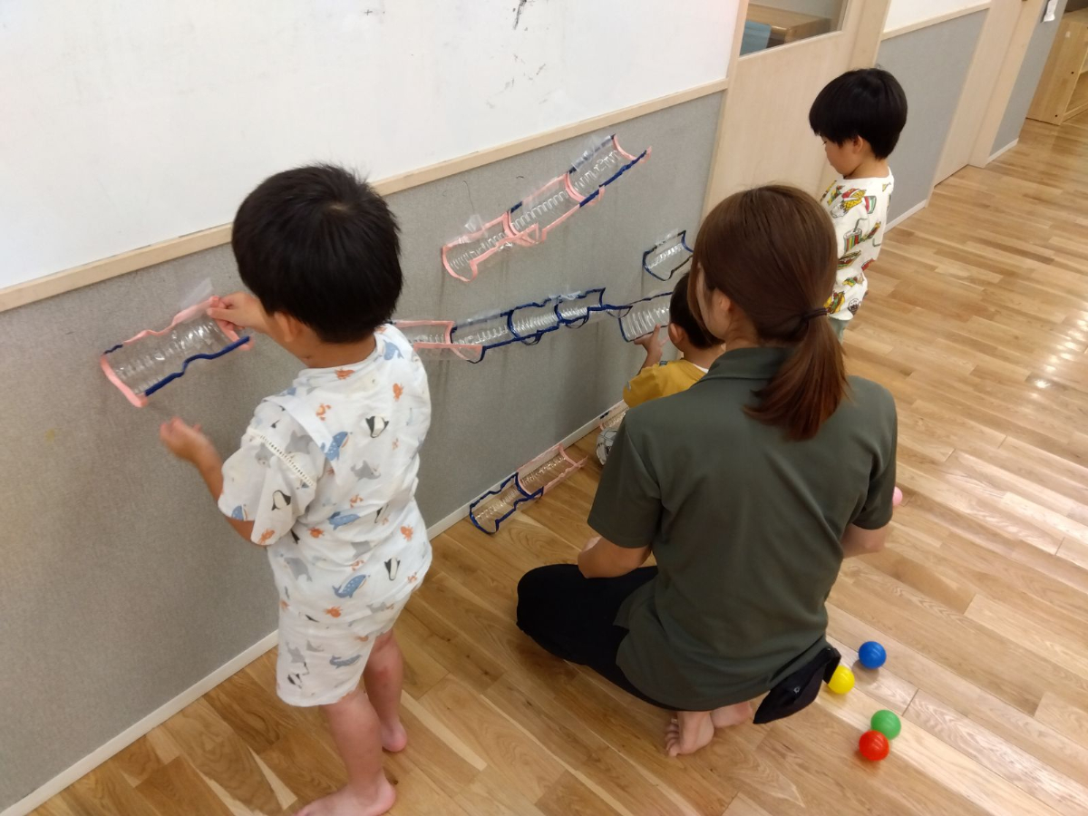ペットボトルでコースづくりをする子どもたち