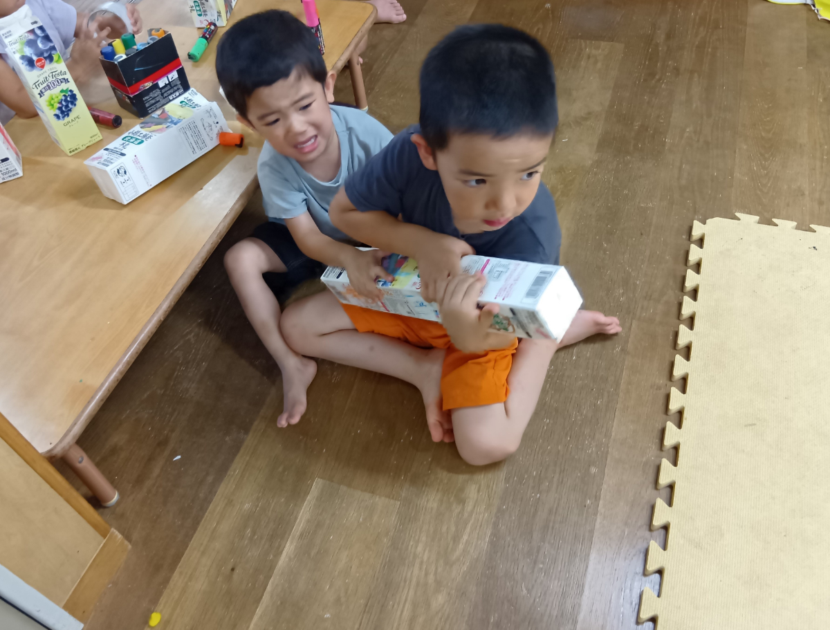 牛乳パックを取りあう子どもたち