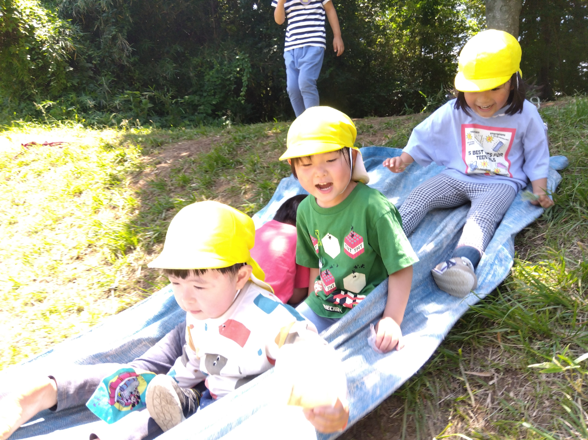 複数人で斜面滑りを楽しむ子どもたち
