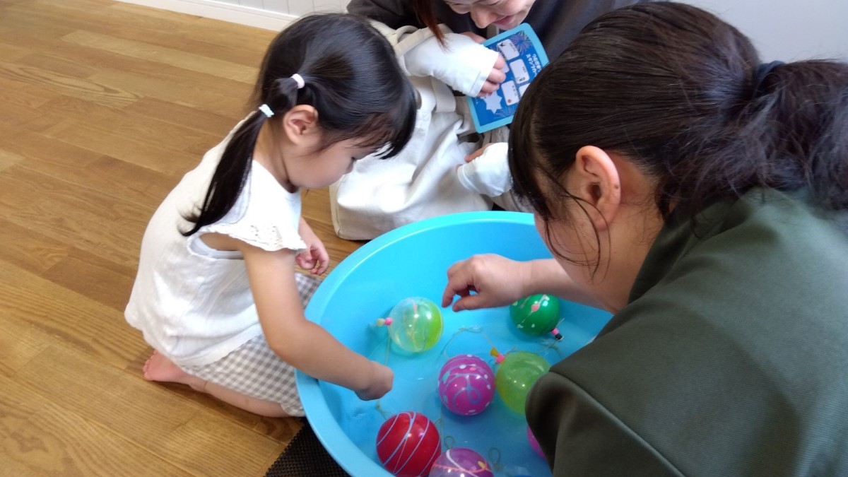 ヨーヨーすくいをする子ども