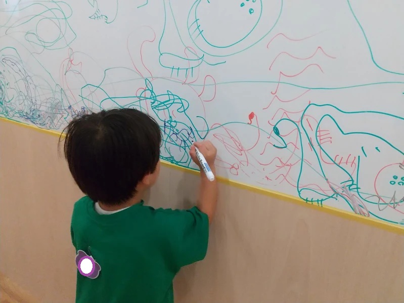 ホワイトボードに絵を描く子ども