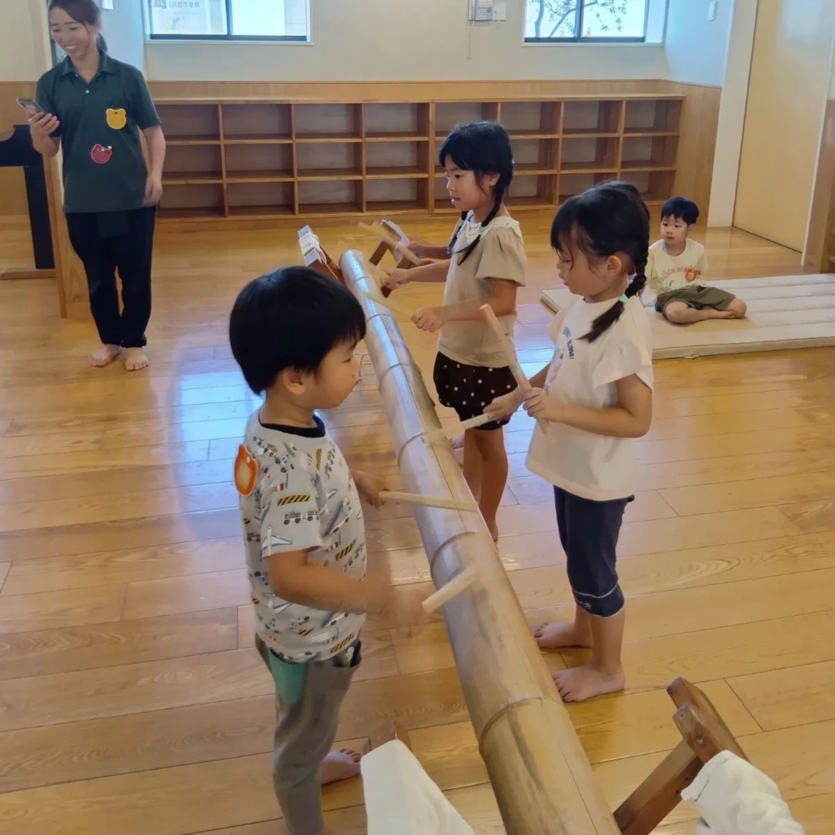 竹太鼓で遊ぶ子どもたち