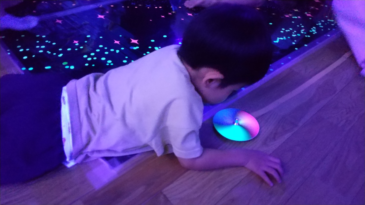 光るコマを見つめる子ども