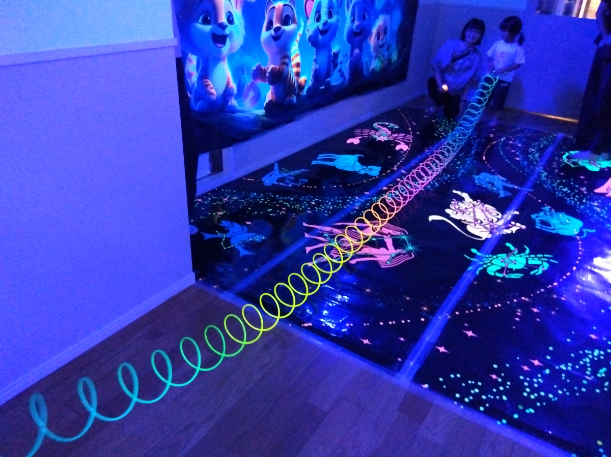 光る玩具を伸ばして遊ぶ子ども