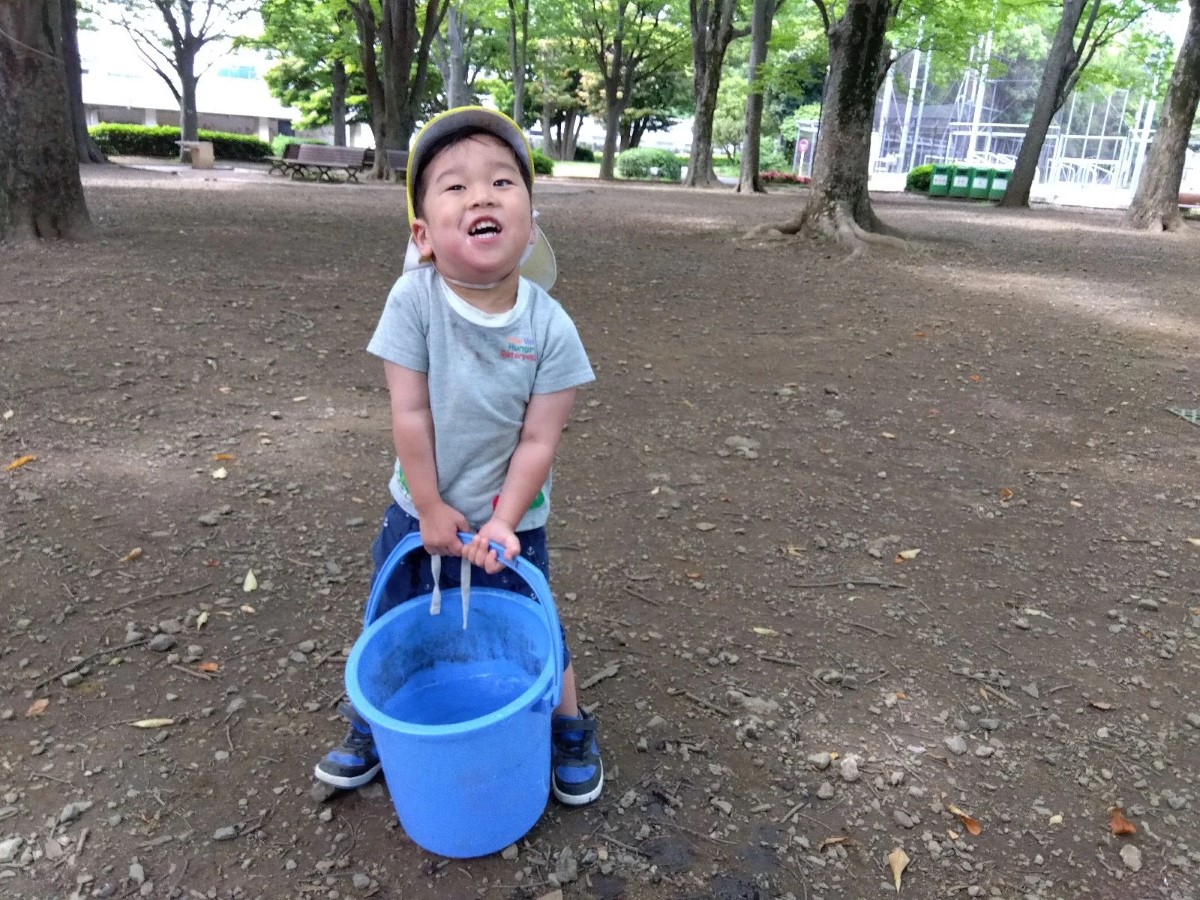 バケツで水を運ぶ子どもたち
