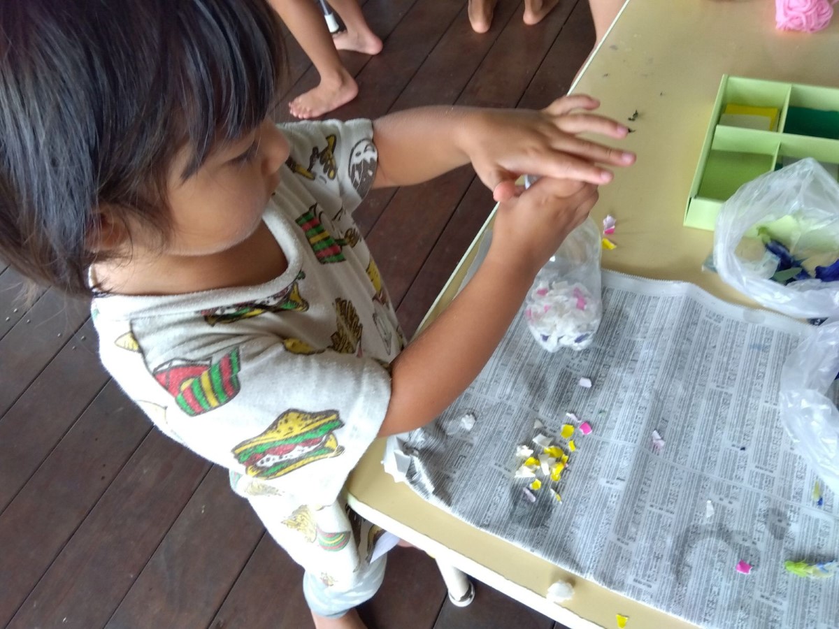 ビニール袋に紙を入れる子ども