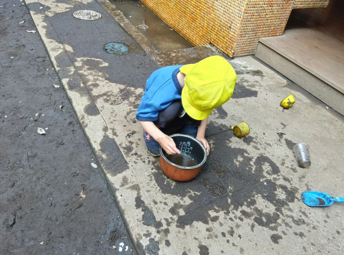 園庭で水遊びをする子ども