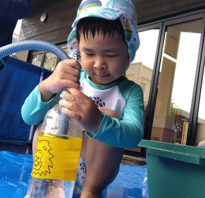 ペットボトルに水を溜める子ども