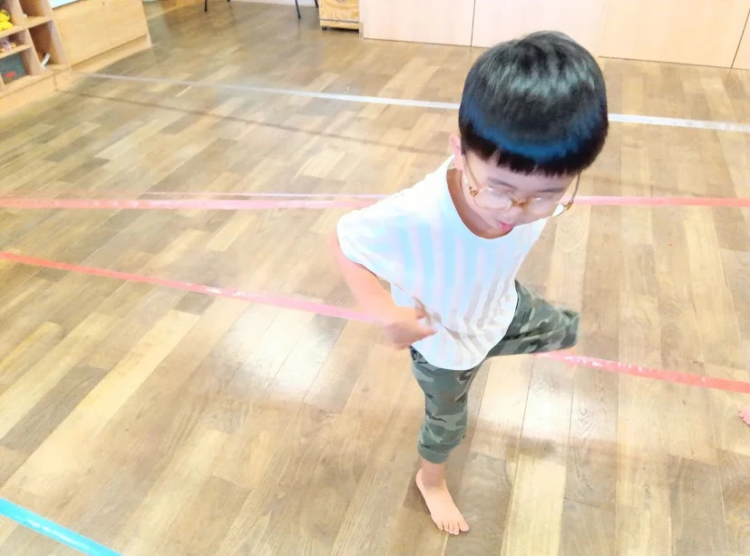 すずらんテープをまたぐ子ども