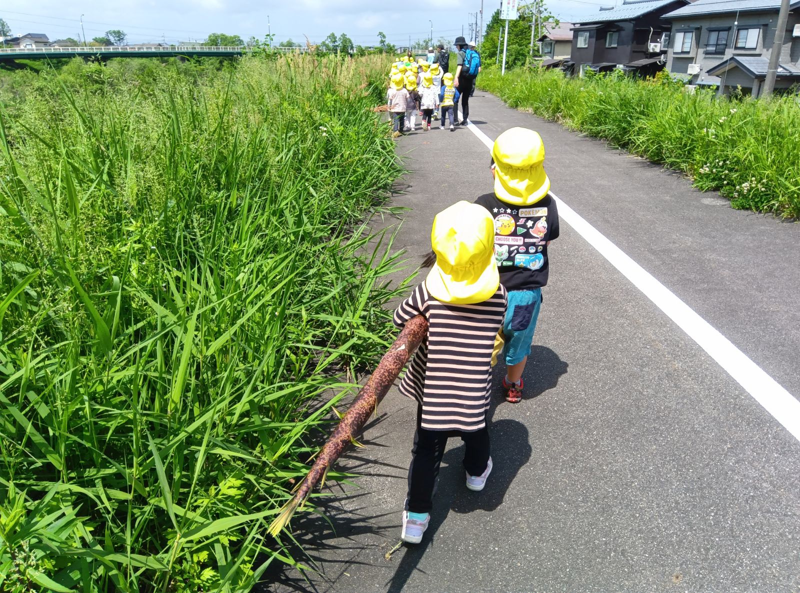 大きいたけのこを運ぶ子どもたち