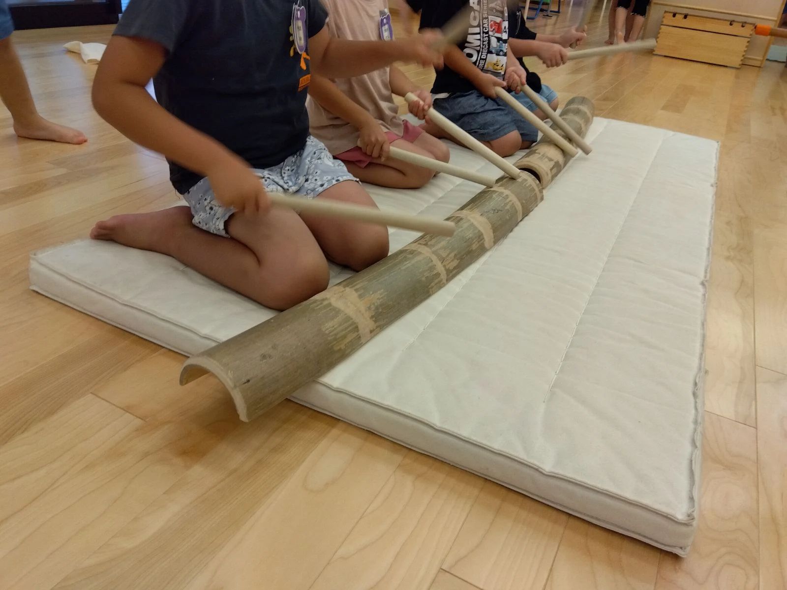 竹を叩いて遊ぶ子どもたち