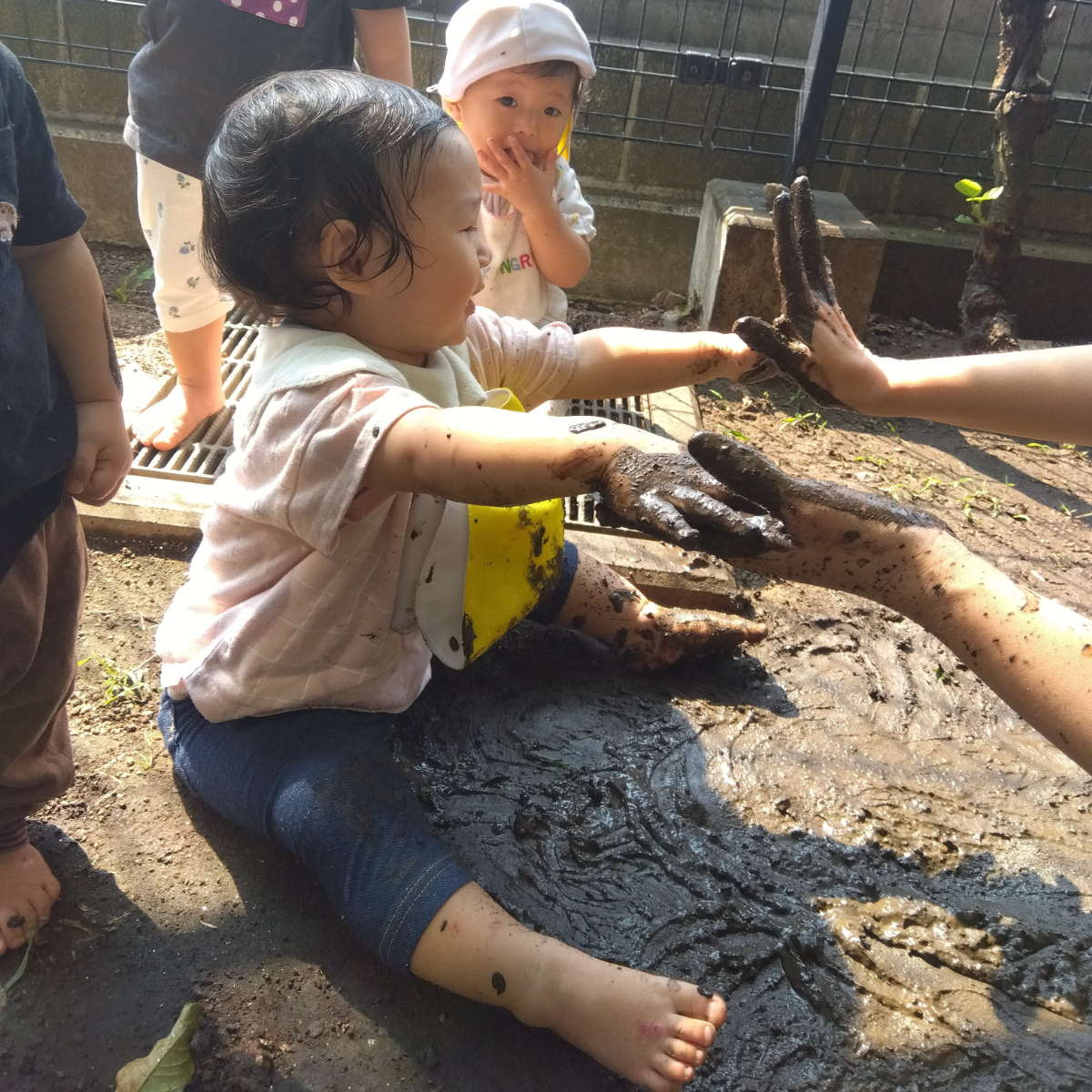 泥遊びをする0歳児
