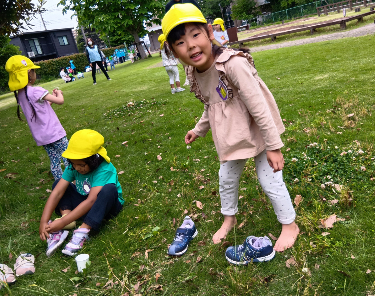 裸足で芝生を踏みしめて遊ぶ子どもたち