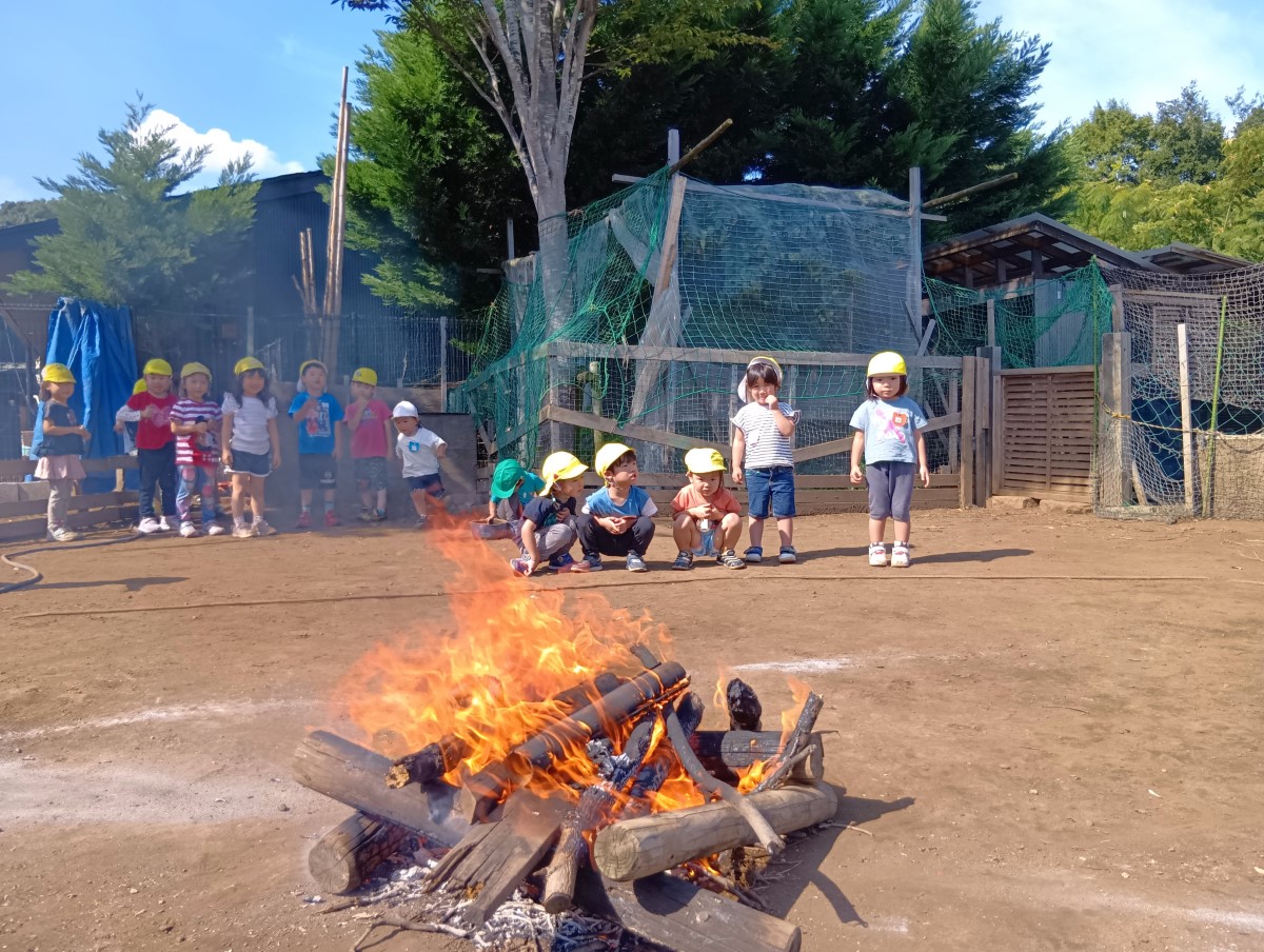 遠巻きに焚き火を眺める子どもたち