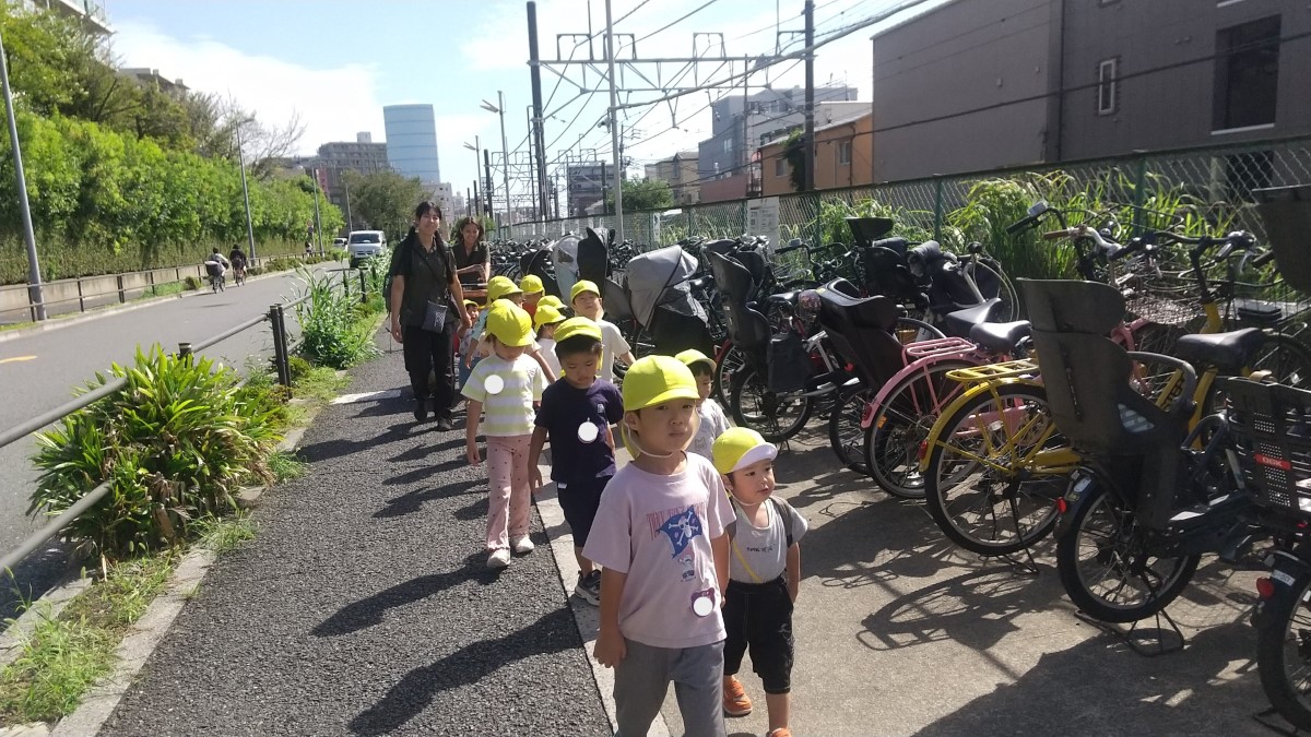 手をつないで歩道を歩く子どもたち