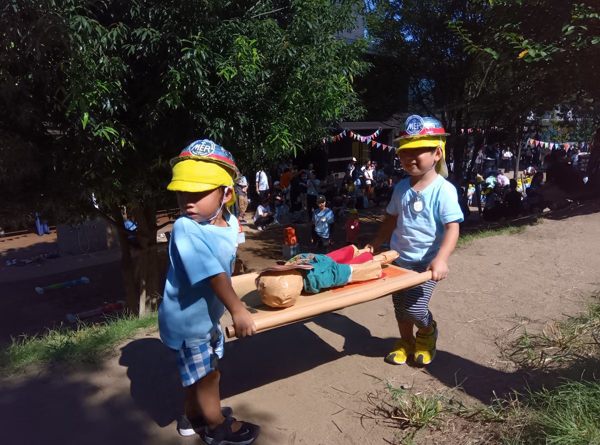 担架を使って人形を運ぶ子どもたち