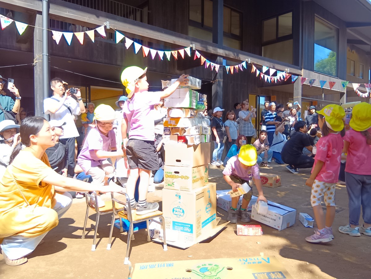 段ボールや牛乳パックを積み上げる子どもたち