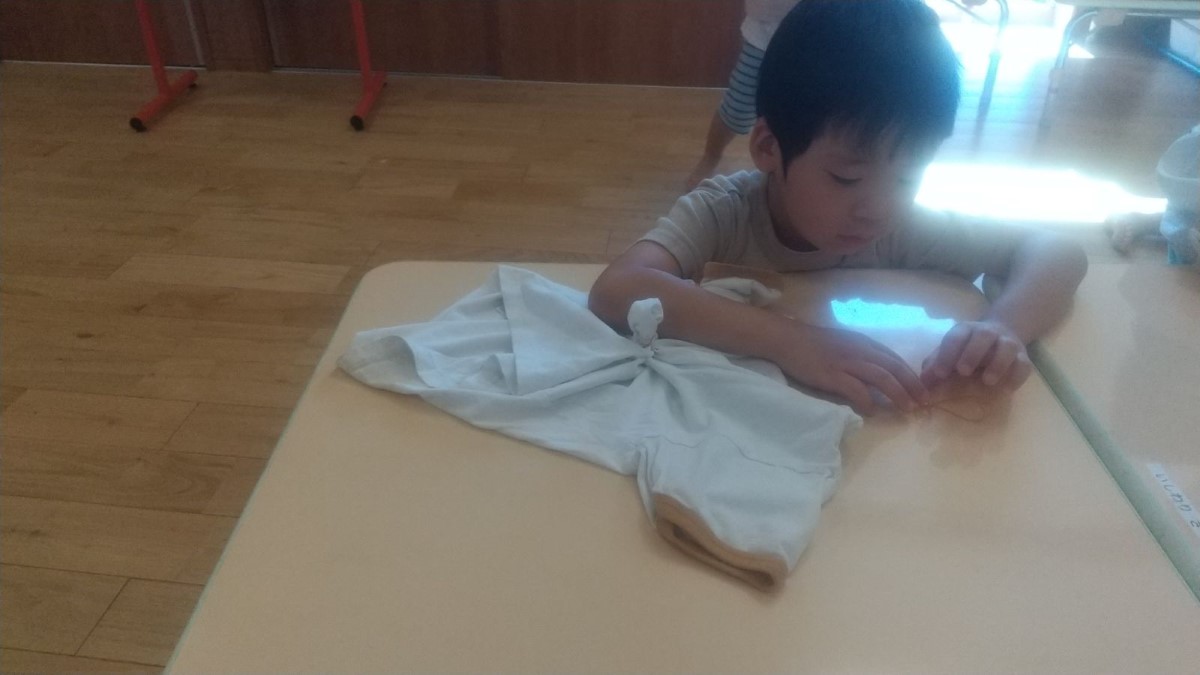 Tシャツを輪ゴムで縛る子ども
