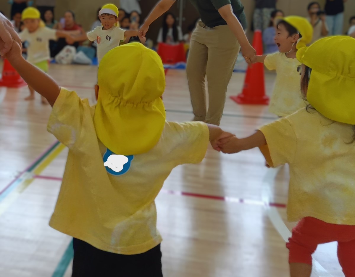 手をつないで輪になる子どもたち