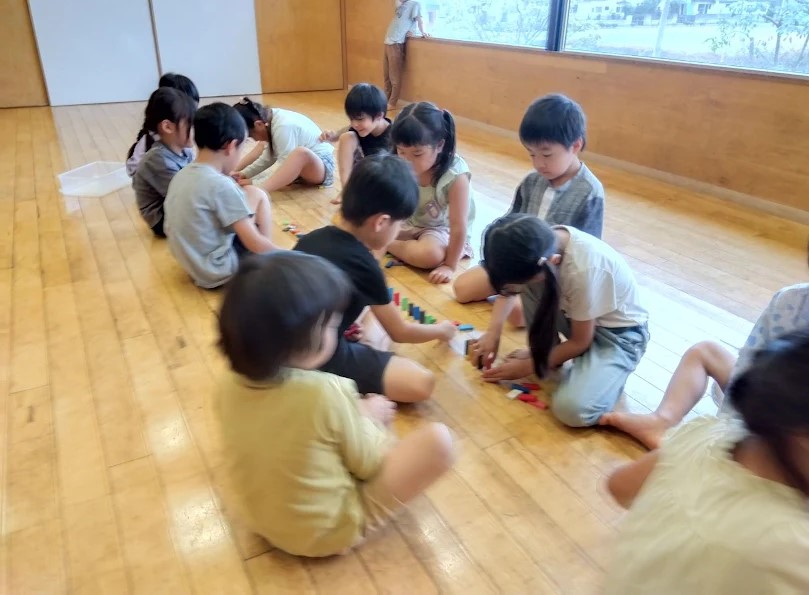 保育室内で協力してドミノを並べる子どもたち