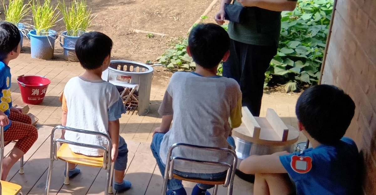 火起こしの説明を受ける子どもたち