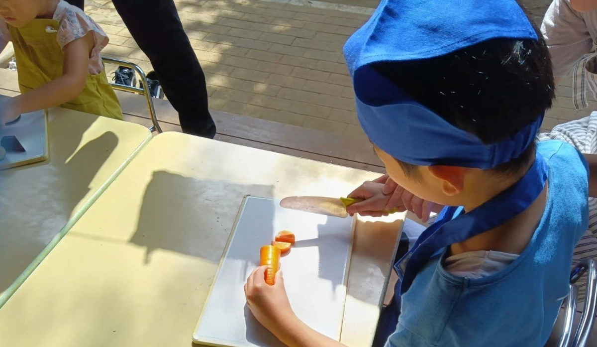 包丁で野菜を切る子ども