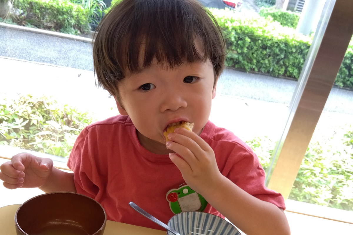 チキンカツに乗せてケチャップを味わう子ども