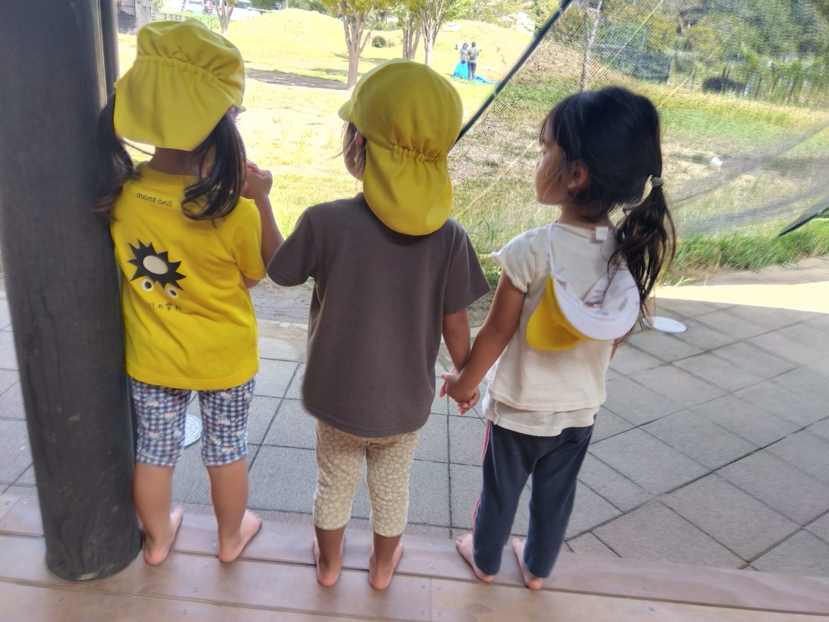 縁側で手をつなぐ子どもたち