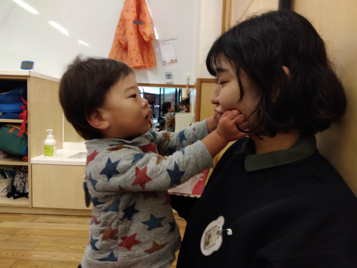 スタッフの顔を触る子ども