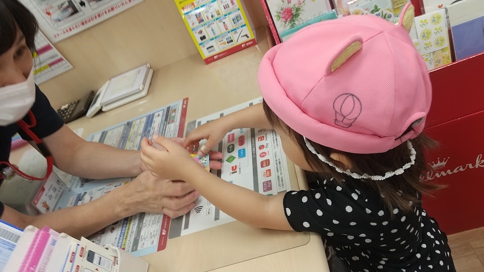 郵便局職員にひまわりの種を渡す子ども