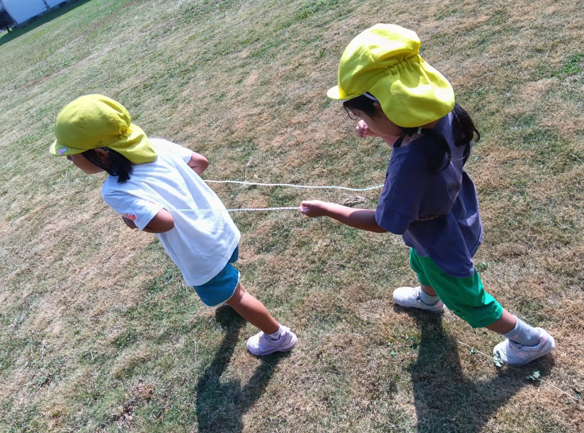 縄跳びを使って電車ごっこをする子どもたち