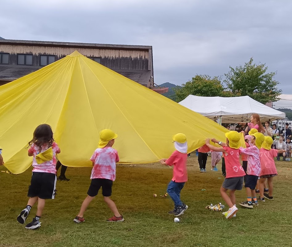 黄色いパラバルーンに取り組む子どもたち