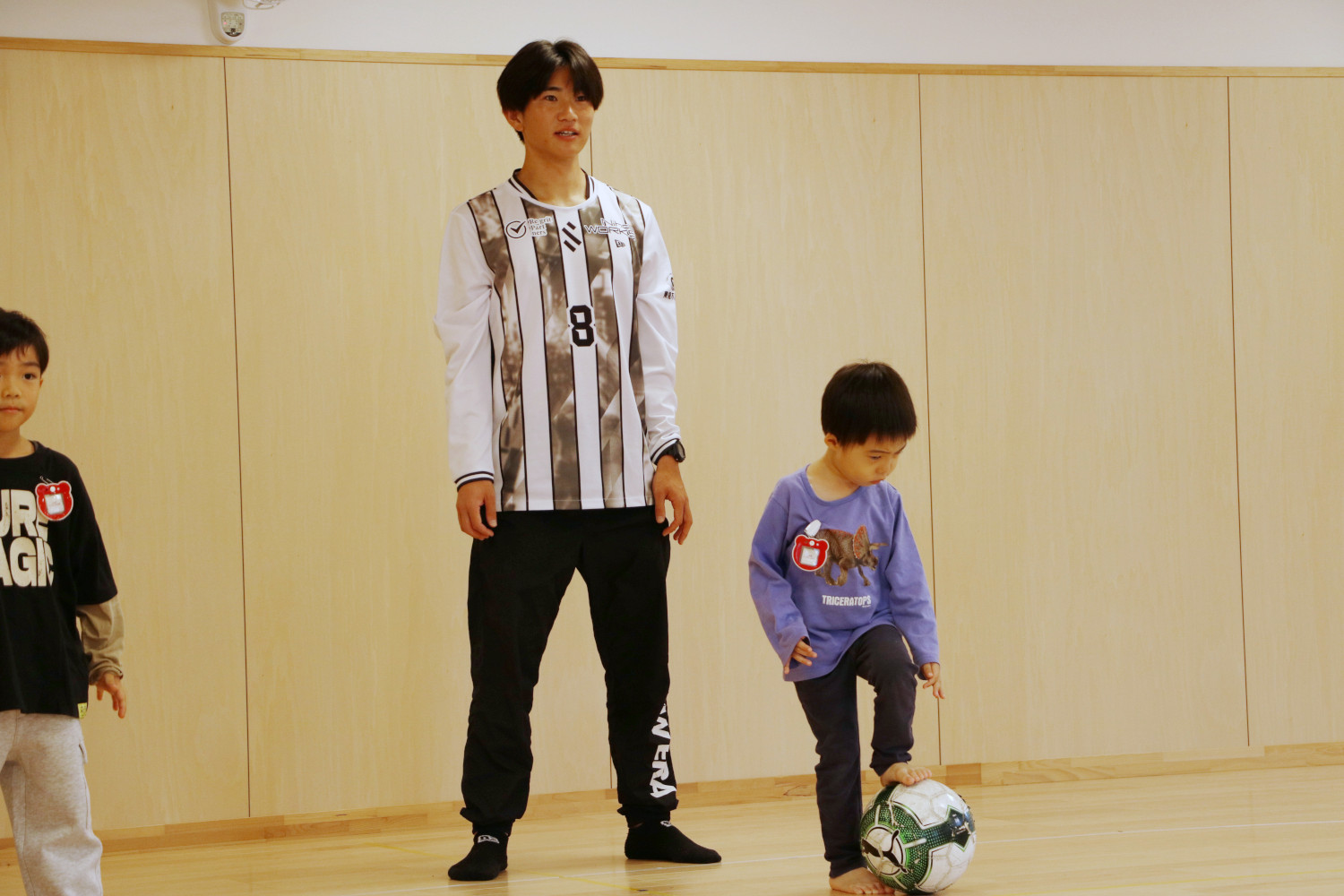 子どもたちにパスの出し方を教える植松選手