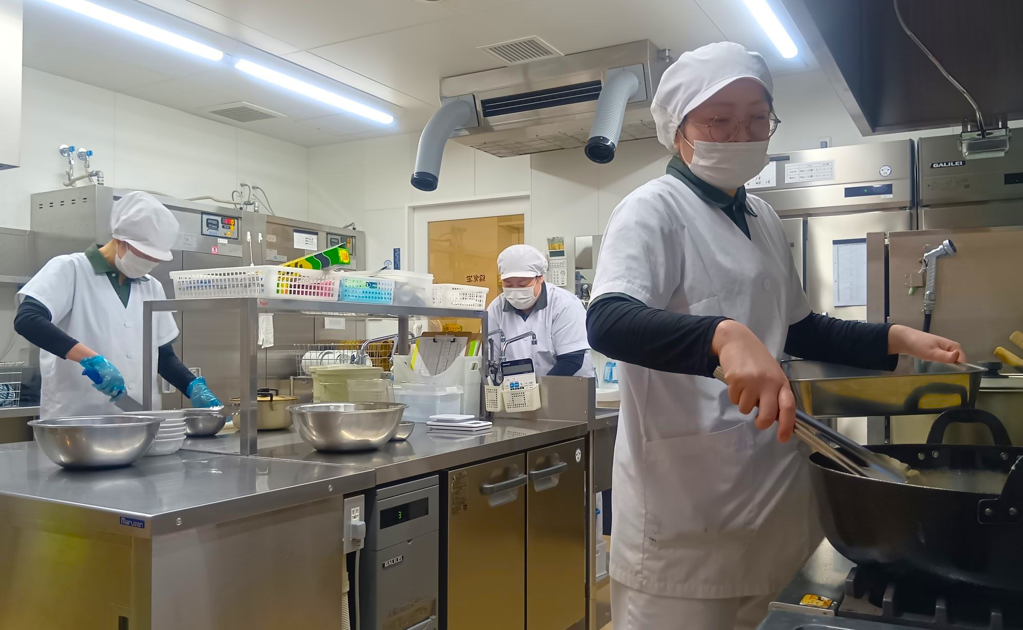 給食室で調理スタッフが調理する様子