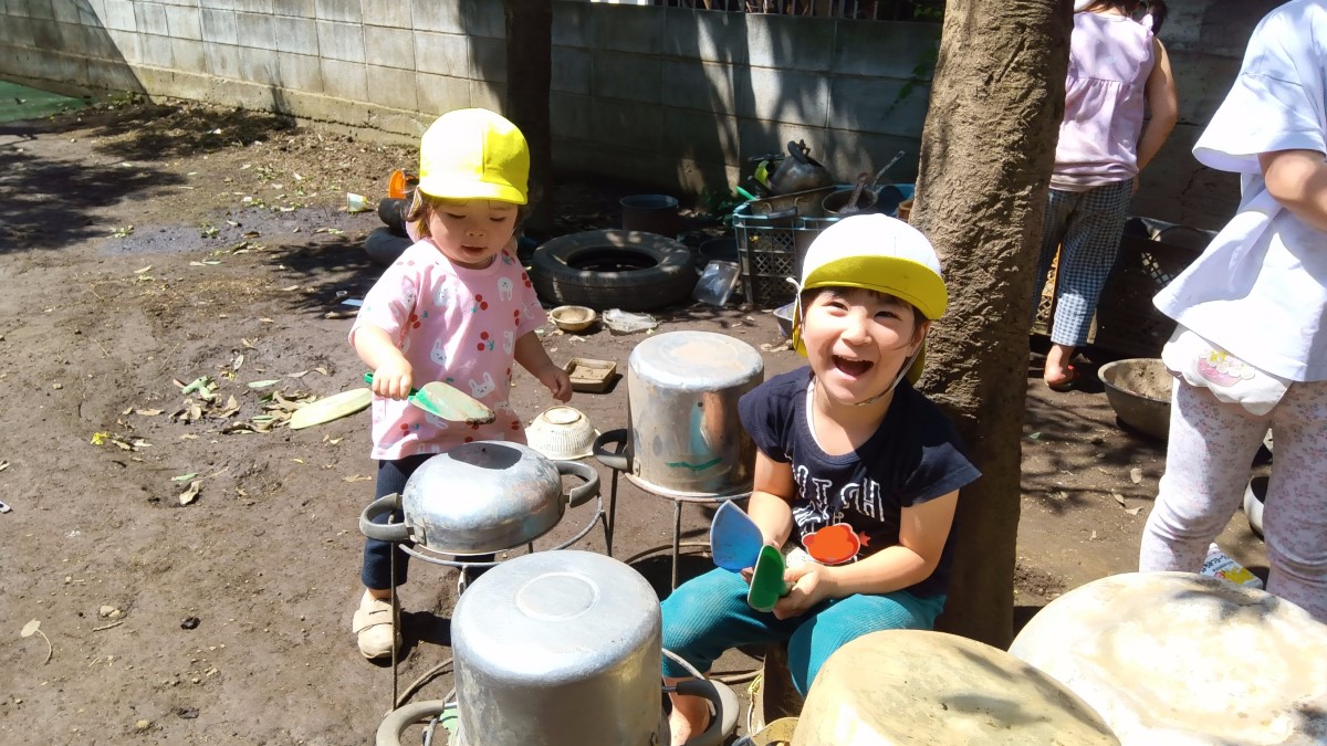 園庭で泥遊びをする子どもたち